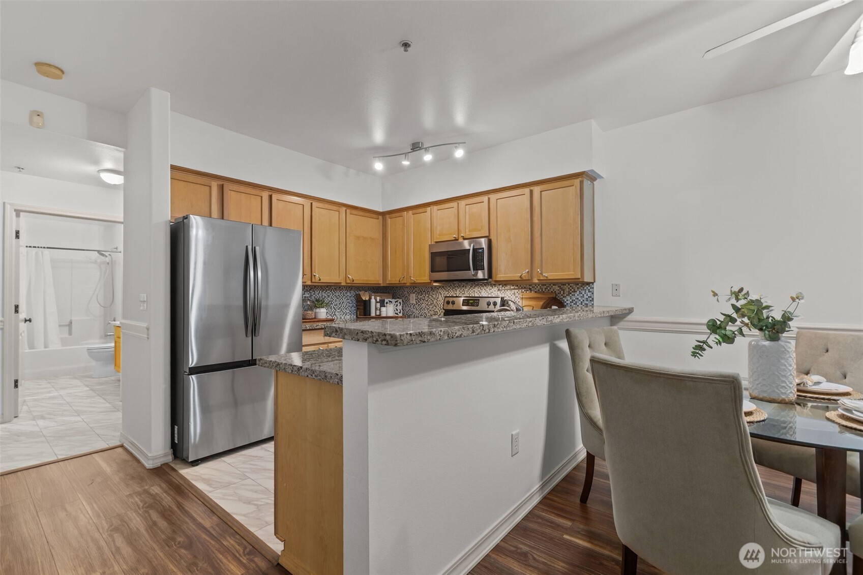 440 Maple Avenue Southwest, Unit A106 Renton, WA 98057 - Photo 13 of 39 a kitchen with stainless steel appliances granite countertop a refrigerator a sink a stove a dining table and chairs