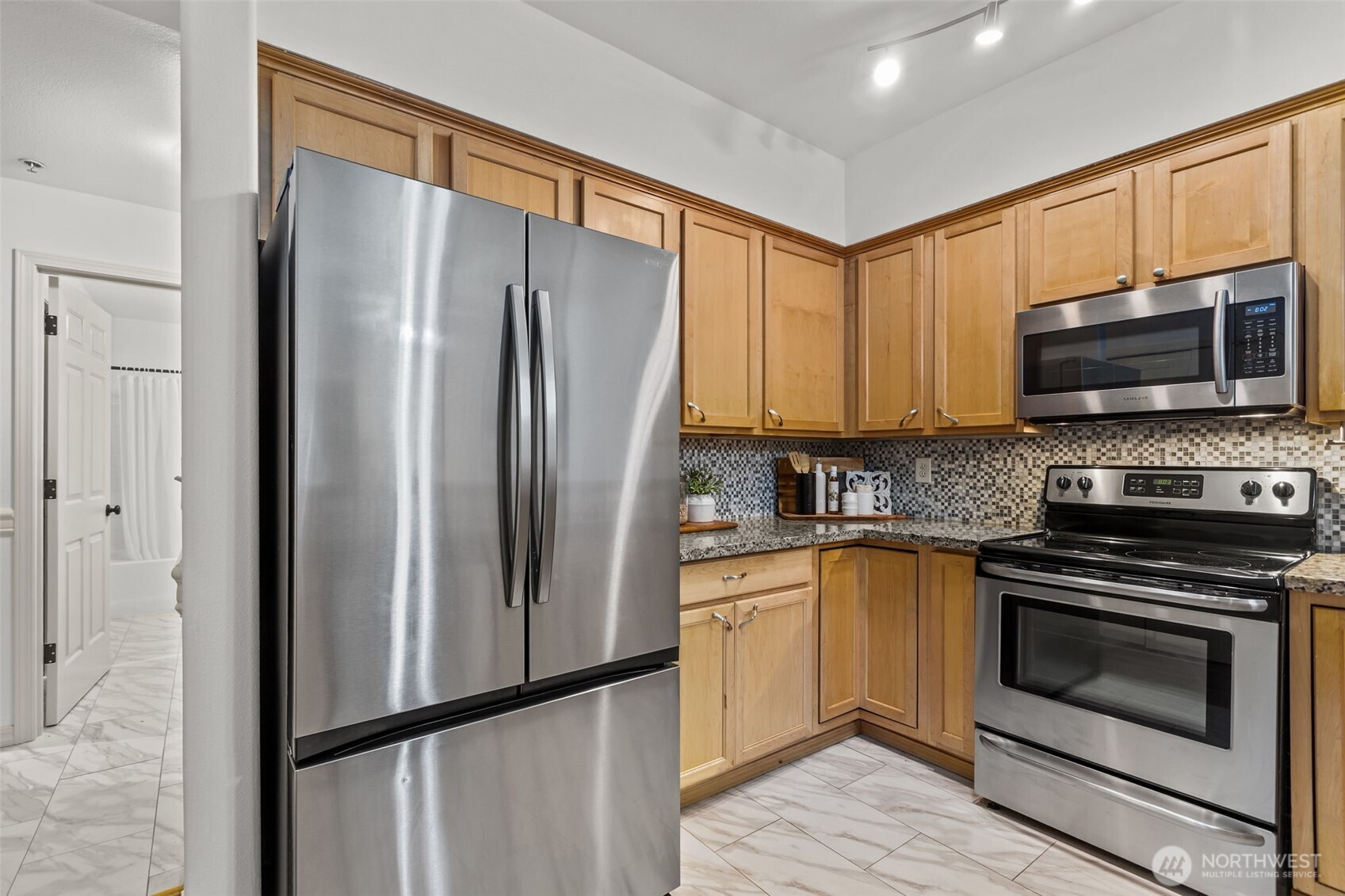 440 Maple Avenue Southwest, Unit A106 Renton, WA 98057 - Photo 14 of 39 a kitchen with granite countertop a refrigerator stove and microwave