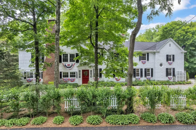 a front view of a house with a yard and potted plants