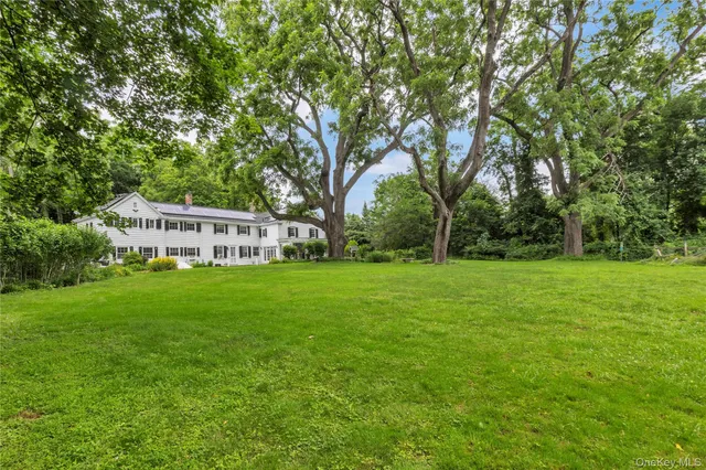 a view of a white house next to a yard