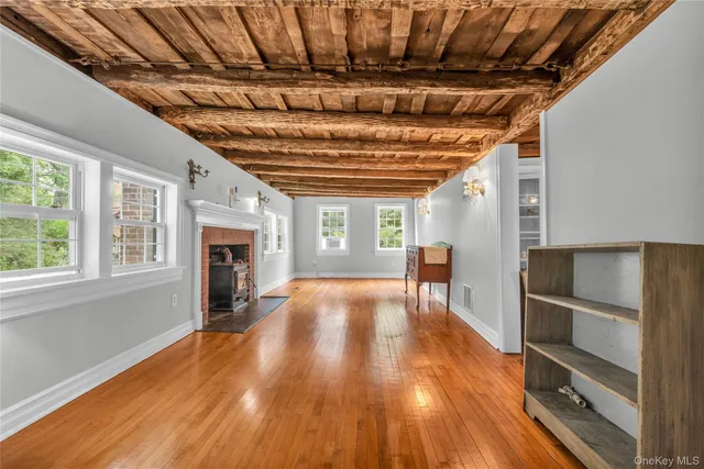 a view of empty room with wooden floor and fireplace