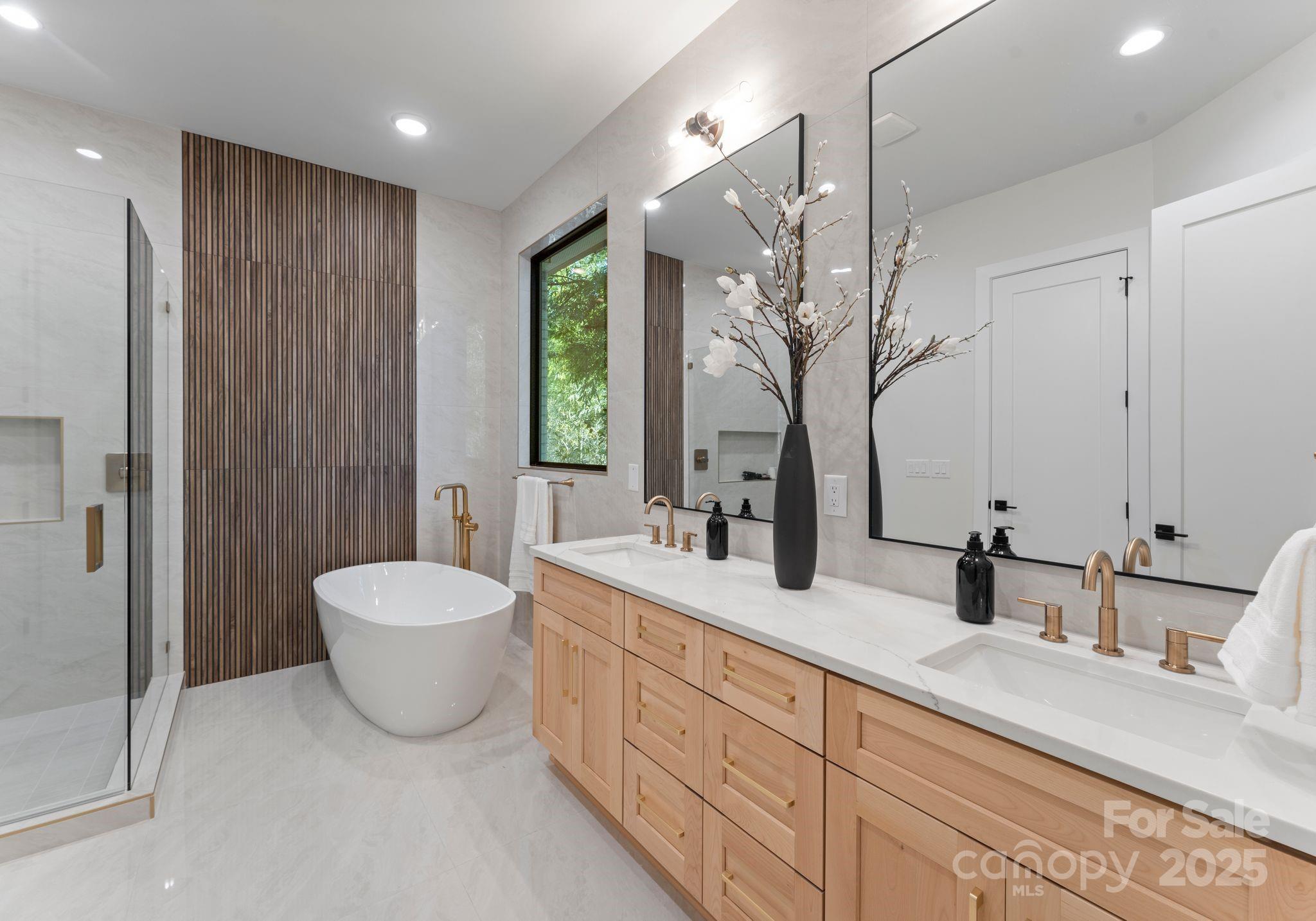 4641 Connecting Road Charlotte, NC 28209 - Photo 26 of 48 a spacious bathroom with a double vanity sink a mirror and a bathtub