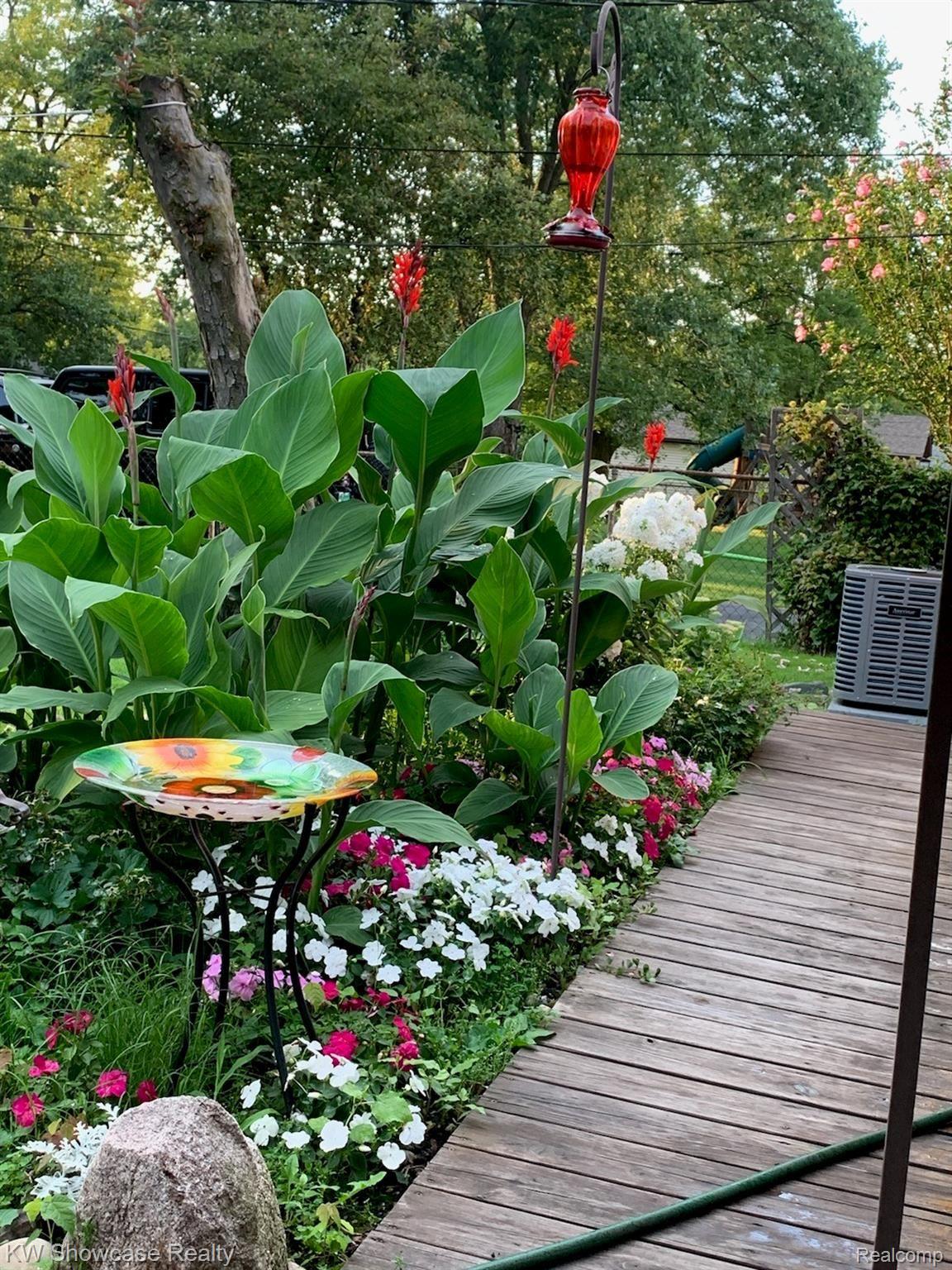 Flower bed by the deck, walkway goes all the way to back pedestrian door. Note new air conditioner in 2019