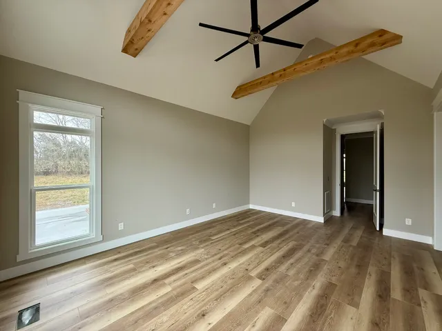 a view of a big room with wooden floor and windows