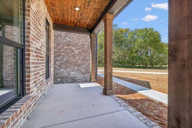 a view of a porch with a floor to ceiling window next to a yard