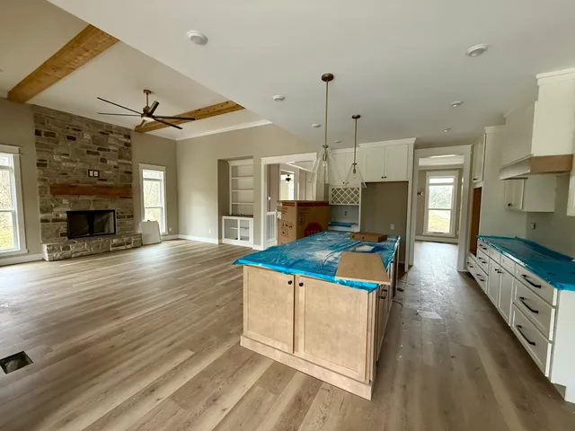 a kitchen with kitchen island a stove a sink and a fireplace
