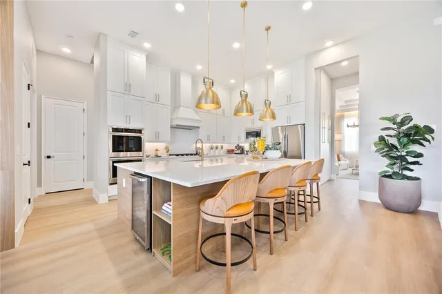 a large white kitchen with a large counter top appliances and cabinets