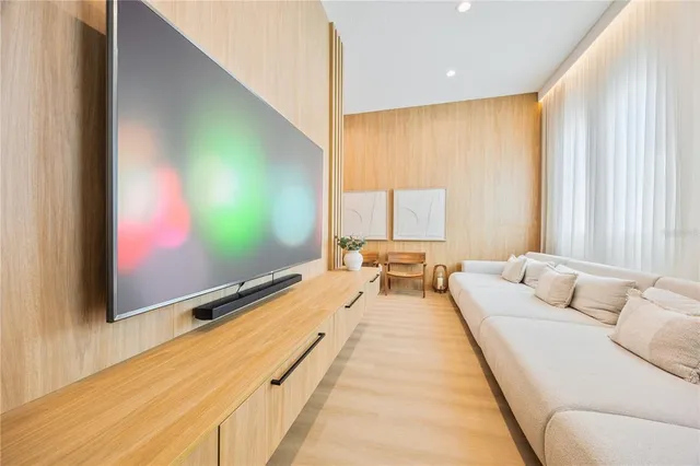 a living room with furniture flat screen tv and a large window