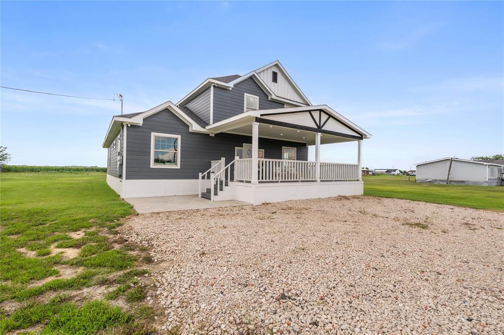 1128 Newton Road Ferris, TX 75125 - Photo 2 of 28 Two-story residence featuring dark gray siding, white trim, and a covered porch with a white railing
