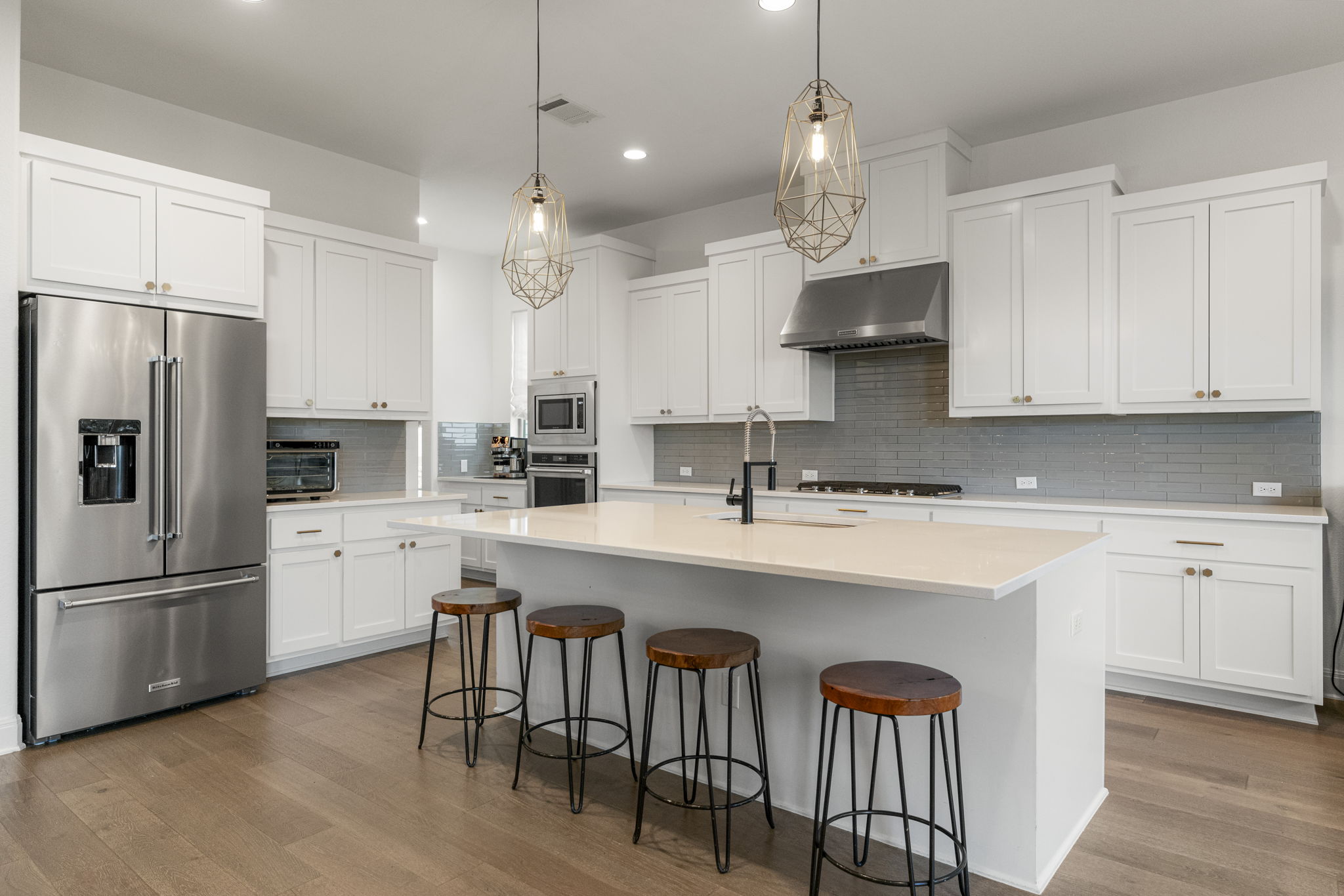 288 Hazy Hills Loop Dripping Springs, TX 78620 - Photo 5 of 40 A bright, open kitchen with a large island, elevated finishes, custom lighting, and a layout designed for both everyday living and entertaining.