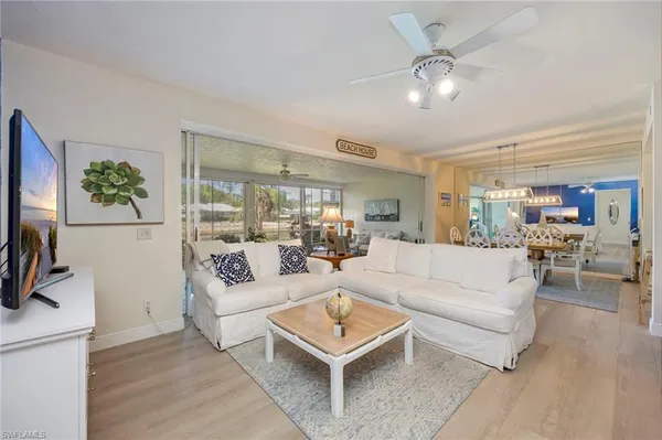 a living room with furniture a flat screen tv and a table