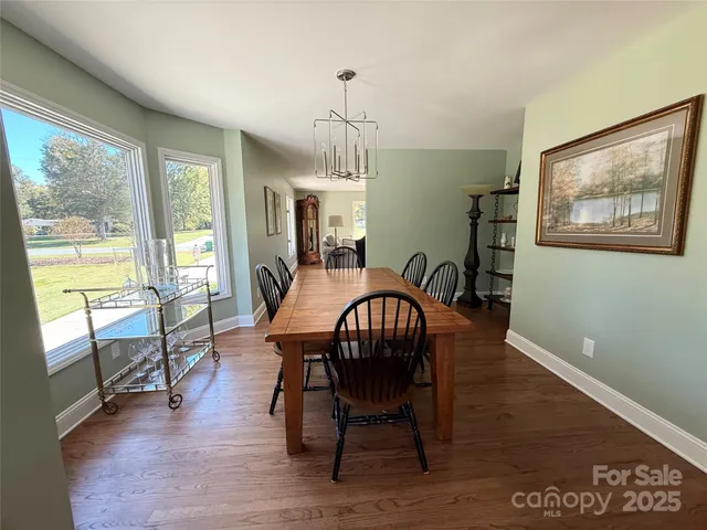 a dining room with furniture a chandelier and wooden floor