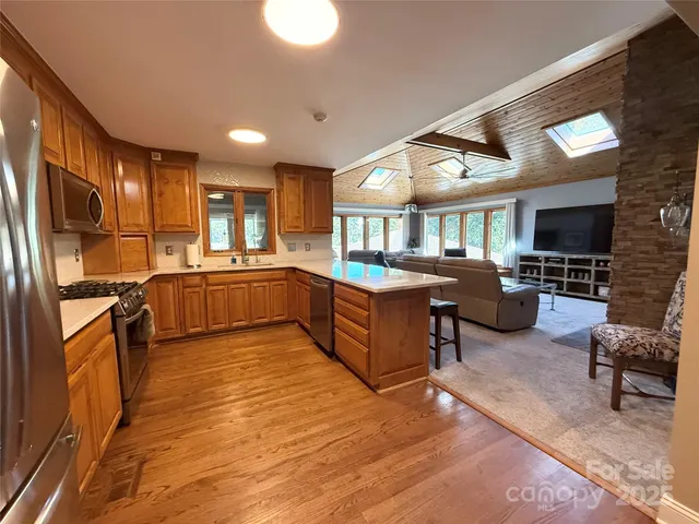 a large open kitchen with a refrigerator a stove top oven and a sink