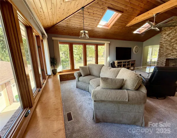 a living room with furniture a flat screen tv and a large window