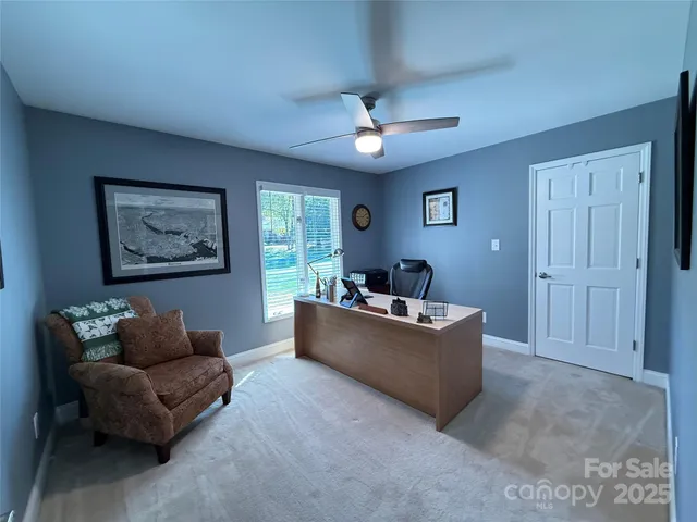 a living room with furniture and a ceiling fan