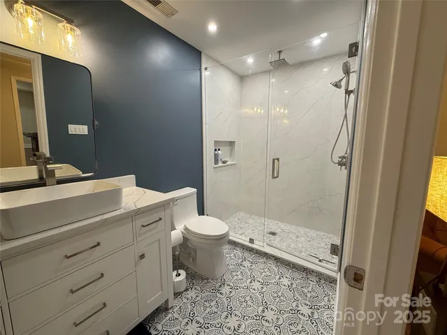 a bathroom with a granite countertop sink toilet and shower