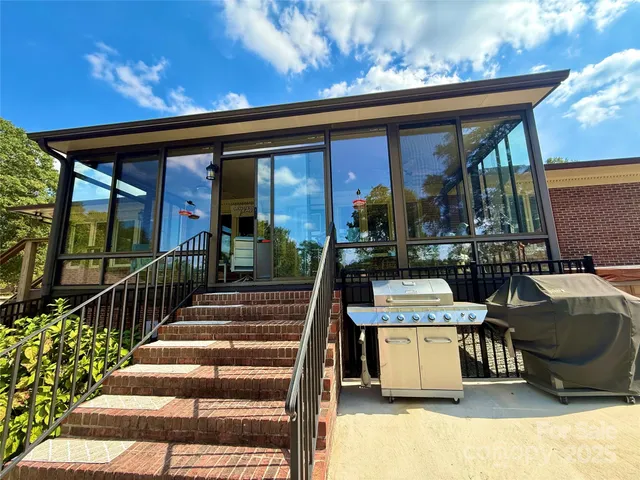 a view of a patio with dining table and chairs with a barbeque grill and plants