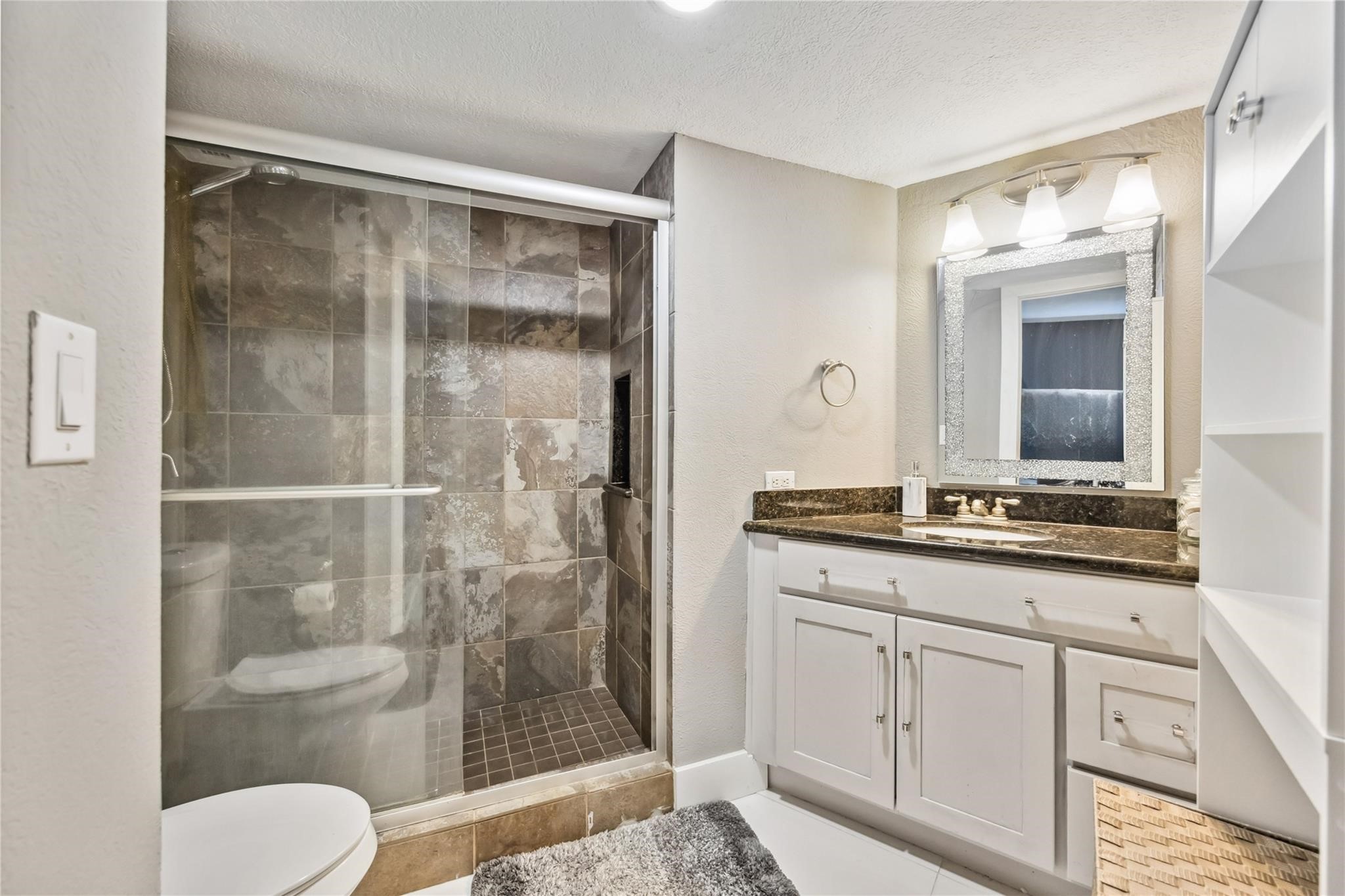 3525 Sage Road, Unit 1713 Houston, TX 77056 - Photo 14 of 25 Elegant walk-in shower with floor-to-ceiling natural stone tile and frameless glass doors—designed for both style and comfort. Come see this spa-inspired retreat in person!