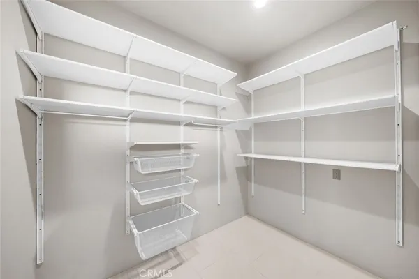 a spacious bedroom with a bed and a flat screen tv