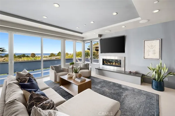 a living room with furniture a flat screen tv and a floor to ceiling window