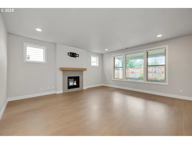 a view of an empty room with a window and fireplace