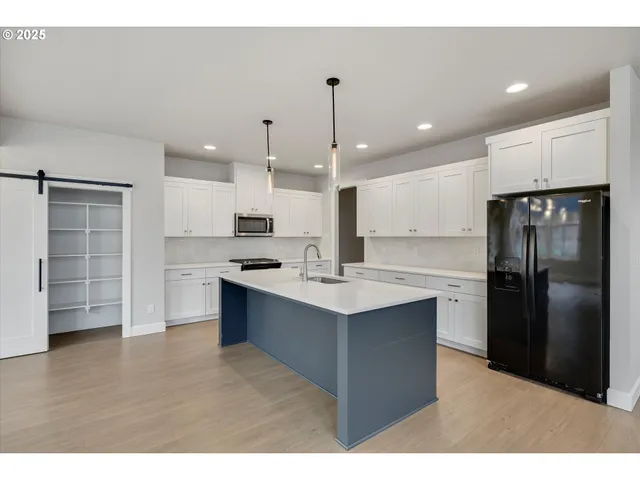 a kitchen with kitchen island a sink stainless steel appliances and cabinets
