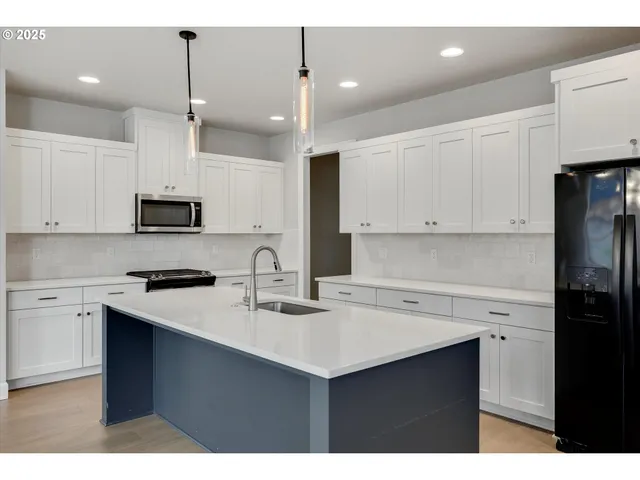 a kitchen with granite countertop white cabinets and black appliances