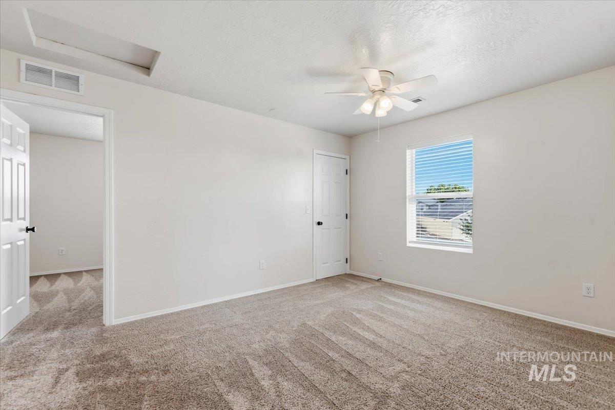 12310 West Hidden Point Drive Star, ID 83669 - Photo 18 of 48 Carpeted room with a ceiling fan, a window featuring horizontal blinds, and a paneled interior door