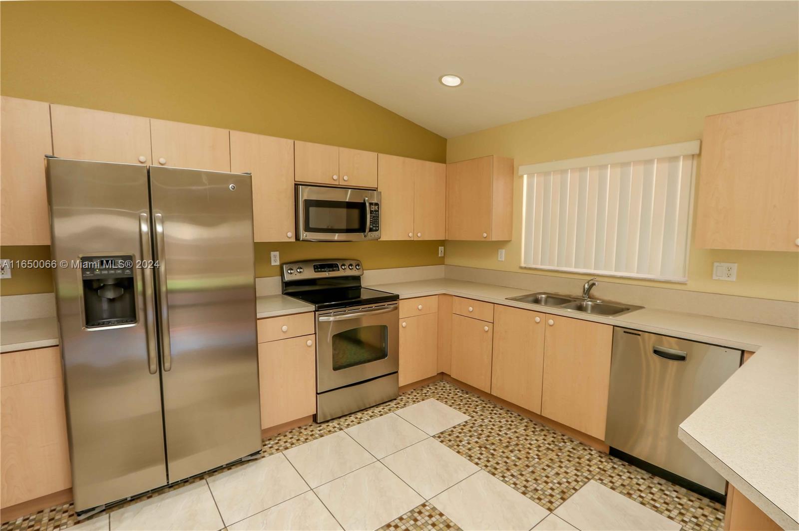 23935 Southwest 108th Place Homestead, FL 33032 - Photo 6 of 30 a kitchen with a refrigerator a sink and a stove