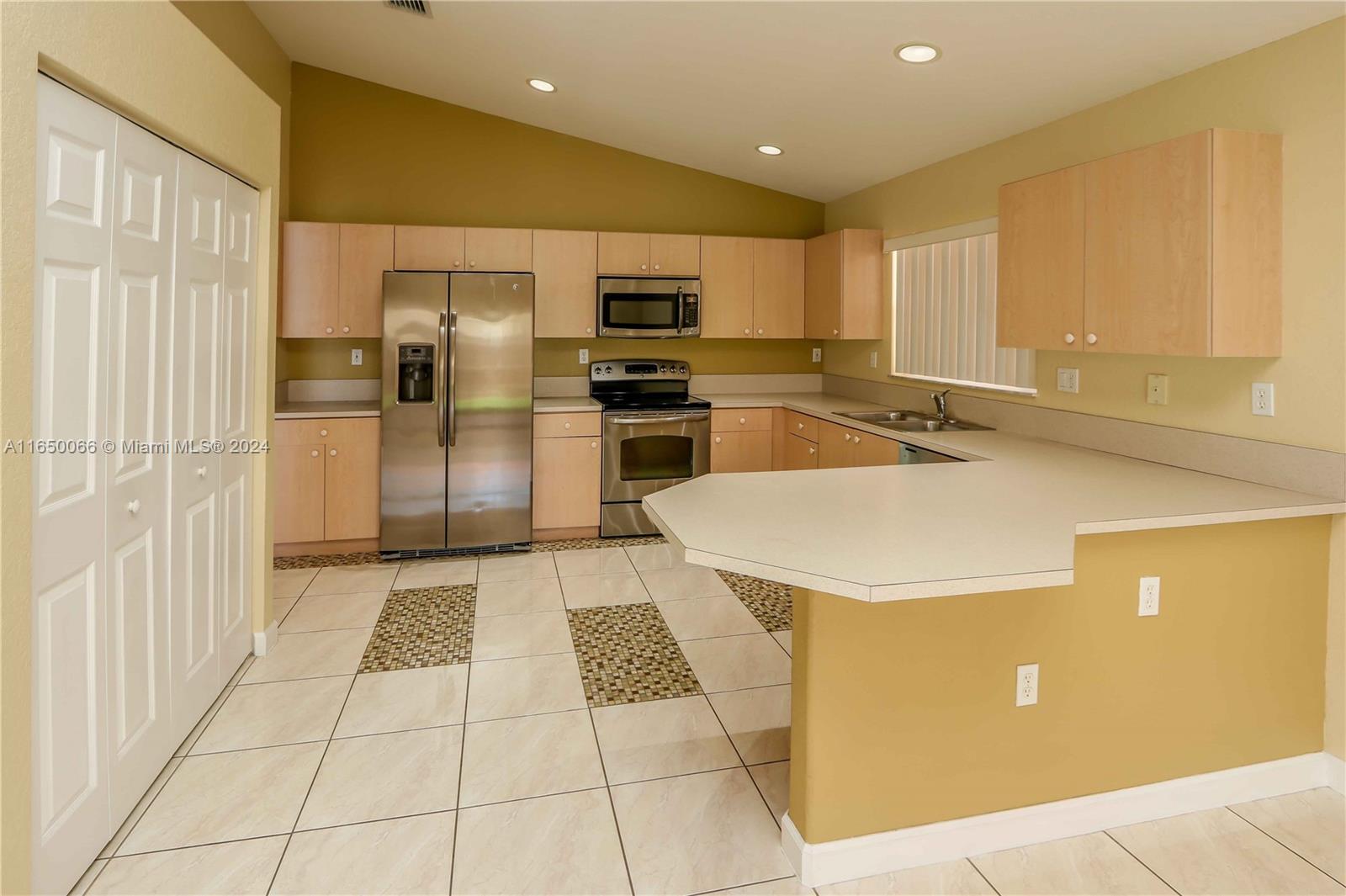 23935 Southwest 108th Place Homestead, FL 33032 - Photo 7 of 30 a kitchen with stainless steel appliances granite countertop a sink refrigerator and cabinets