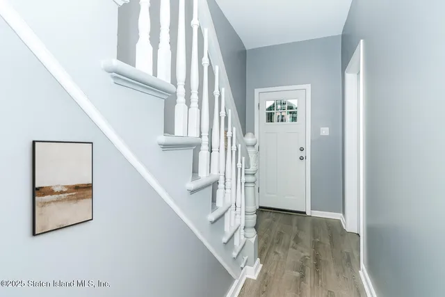 a view of a hallway with wooden floor and staircase