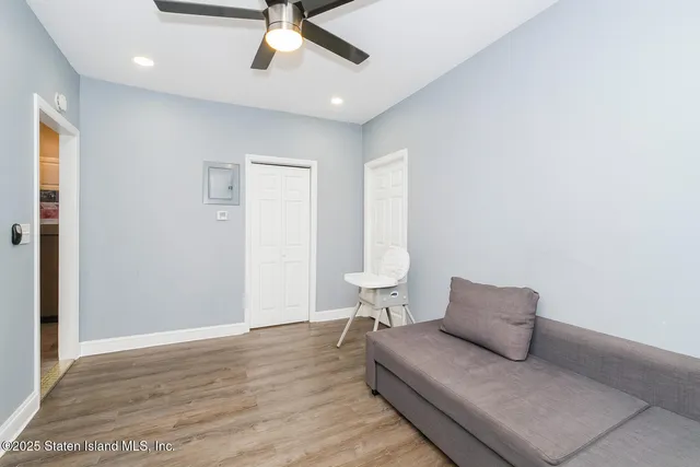 a living room with furniture and a ceiling fan