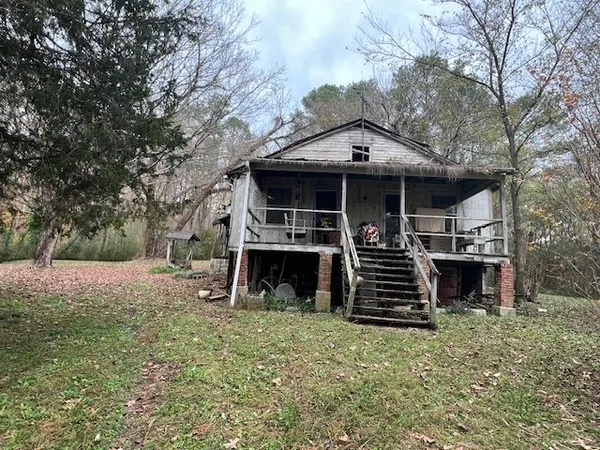 a view of a house with a yard and stairs