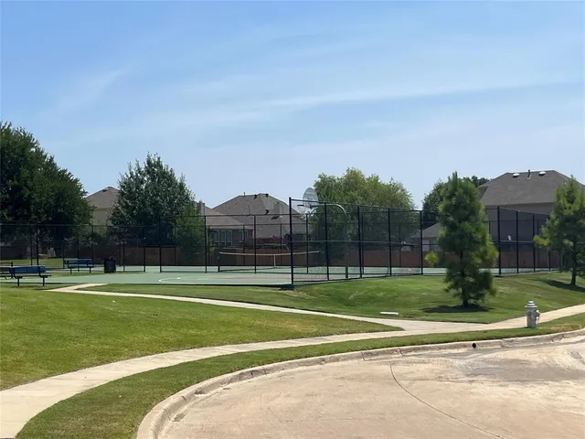 a view of a tennis ground with a big yard
