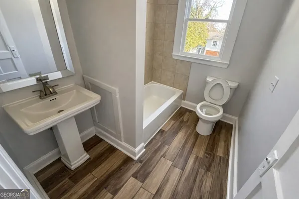 a bathroom with a sink a toilet and bathtub