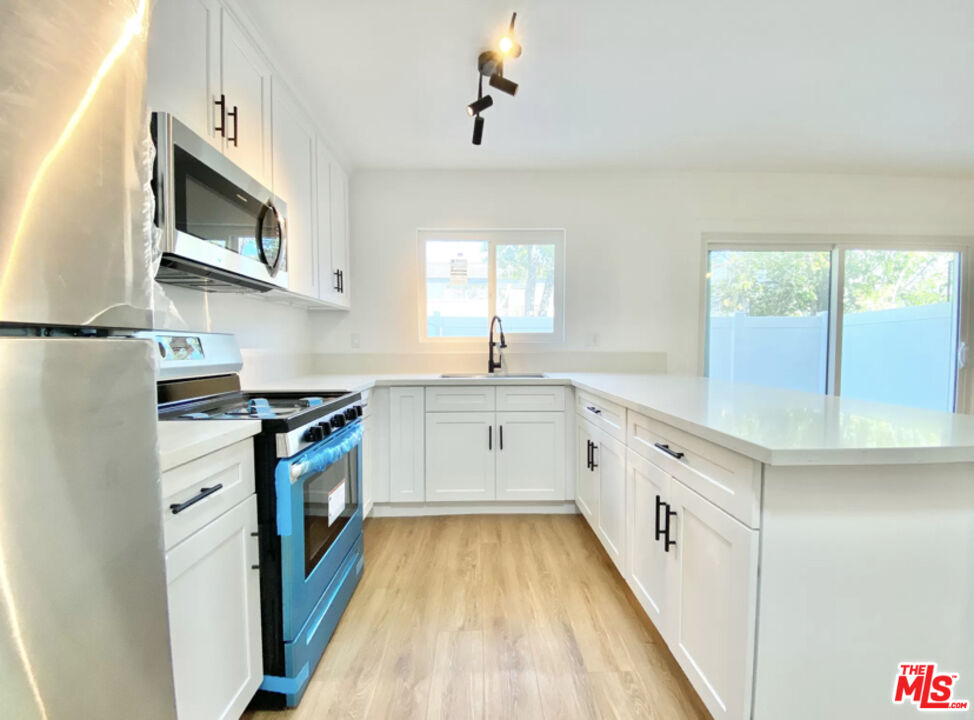 3824 Keystone Avenue, Unit 2 Culver City, CA 90232 - Photo 2 of 10 a kitchen with granite countertop white cabinets and white appliances