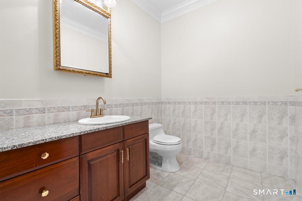 49 Partridge Lane Middletown, CT 06457 - Photo 14 of 39 a bathroom with a granite countertop sink a toilet and a mirror