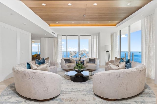 a living room with furniture potted plant and a large window
