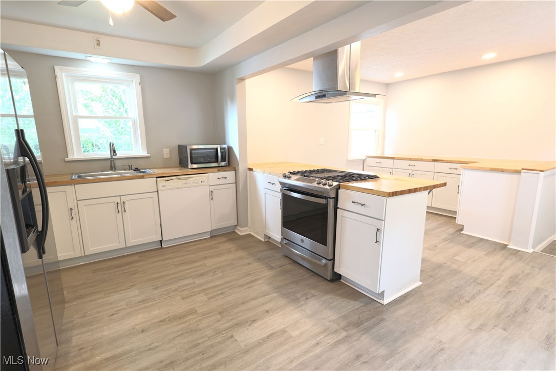 1332 South Green Road South Euclid, OH 44121 - Photo 5 of 23 Kitchen with white cabinetry, butcher block countertops, appliances with stainless steel finishes, and a peninsula