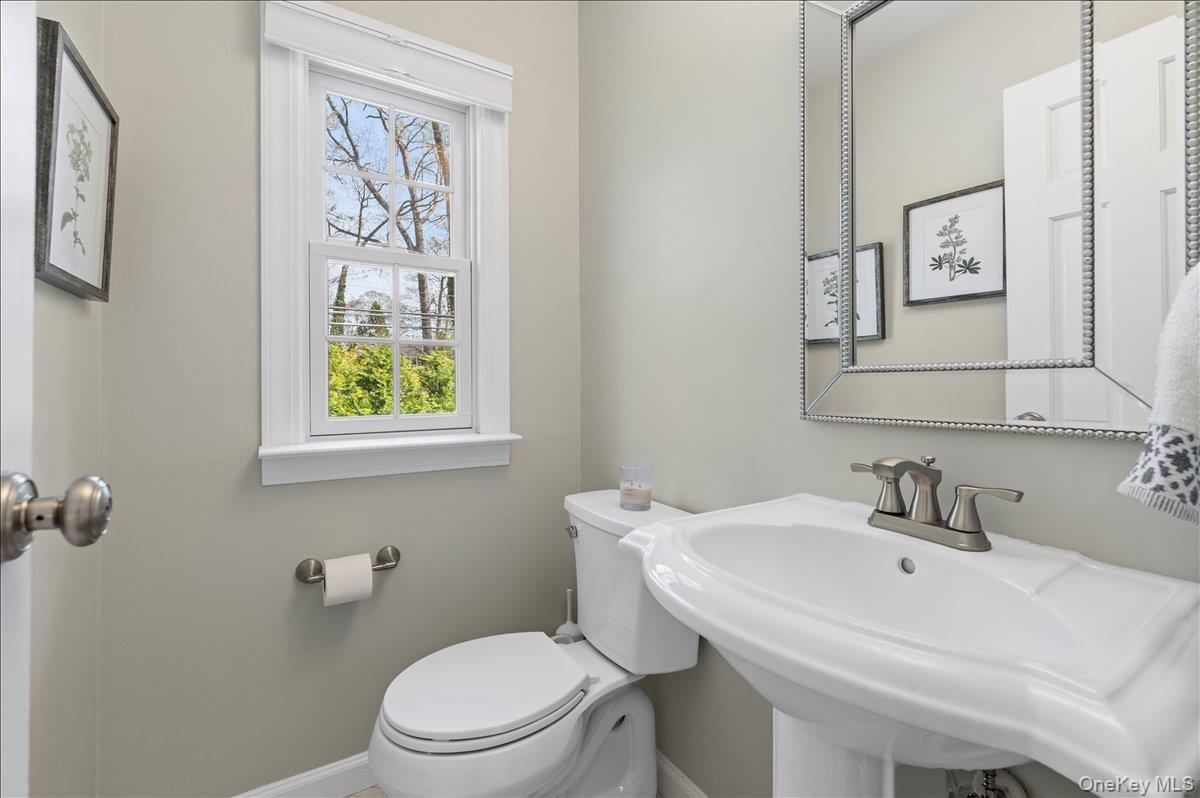 8 Heritage Court Cold Spring Harbor, NY 11724 - Photo 16 of 38 a bathroom with a toilet a sink and mirror