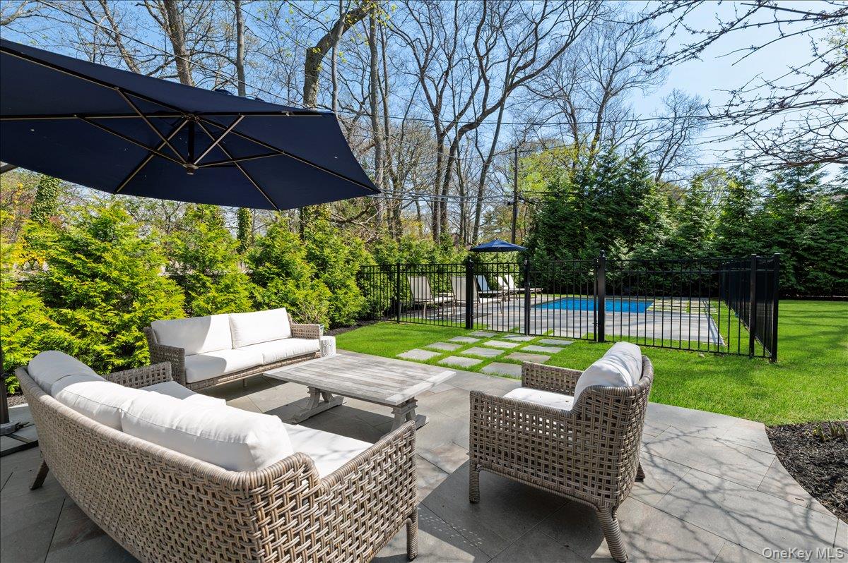 8 Heritage Court Cold Spring Harbor, NY 11724 - Photo 31 of 38 a view of a patio with couches chairs and a umbrella