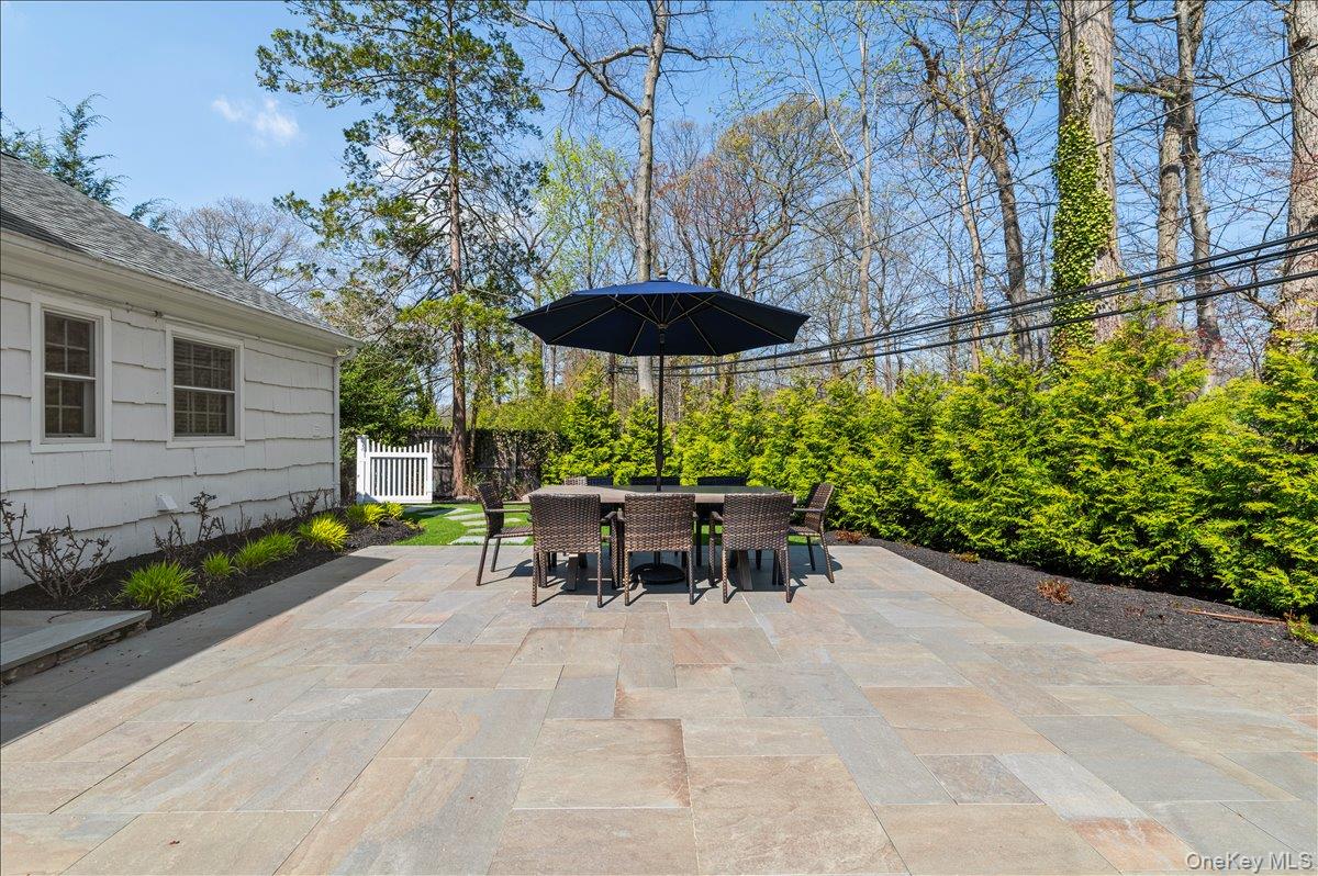 8 Heritage Court Cold Spring Harbor, NY 11724 - Photo 34 of 38 a view of a patio with a table and chairs under an umbrella