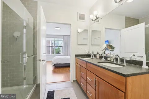 a bathroom with a double vanity sink mirror and shower