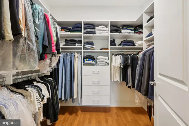 a view of walk in closet with clothes and shoes