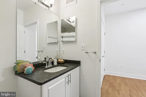 a bathroom with a granite countertop sink and a mirror