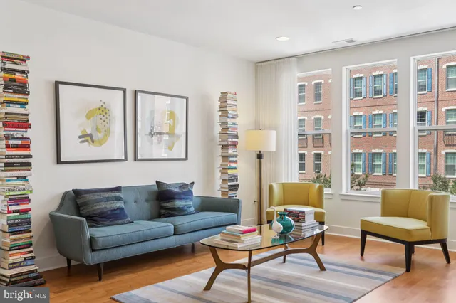 a living room with furniture and a painting on the wall