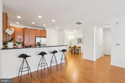 a view of kitchen with stainless steel appliances granite countertop a table and chairs in it