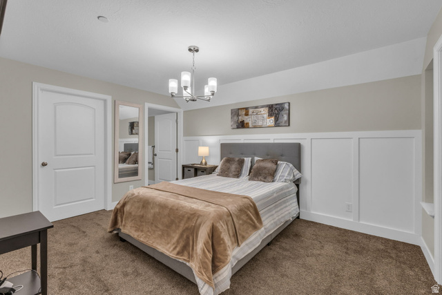 905 South Main Street, Unit G Layton, UT 84041 - Photo 16 of 36 Carpeted bedroom featuring a chandelier, wainscoting, and a decorative wall
