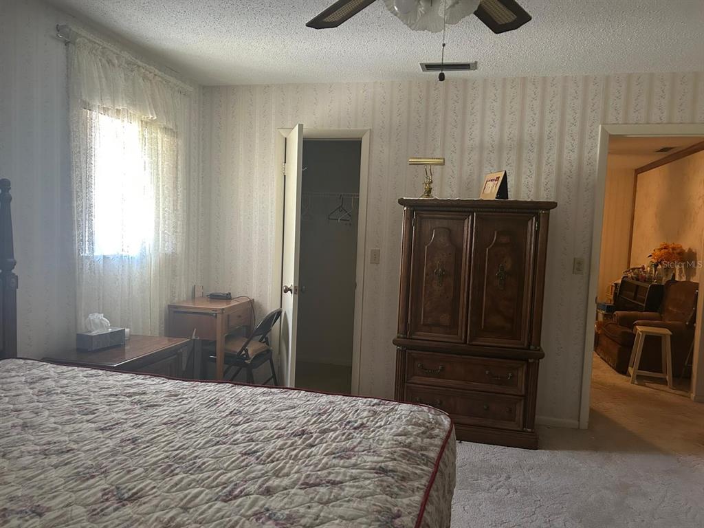 568 Silver Course Loop Ocala, FL 34472 - Photo 6 of 26 a bedroom with a bed and wooden cabinets