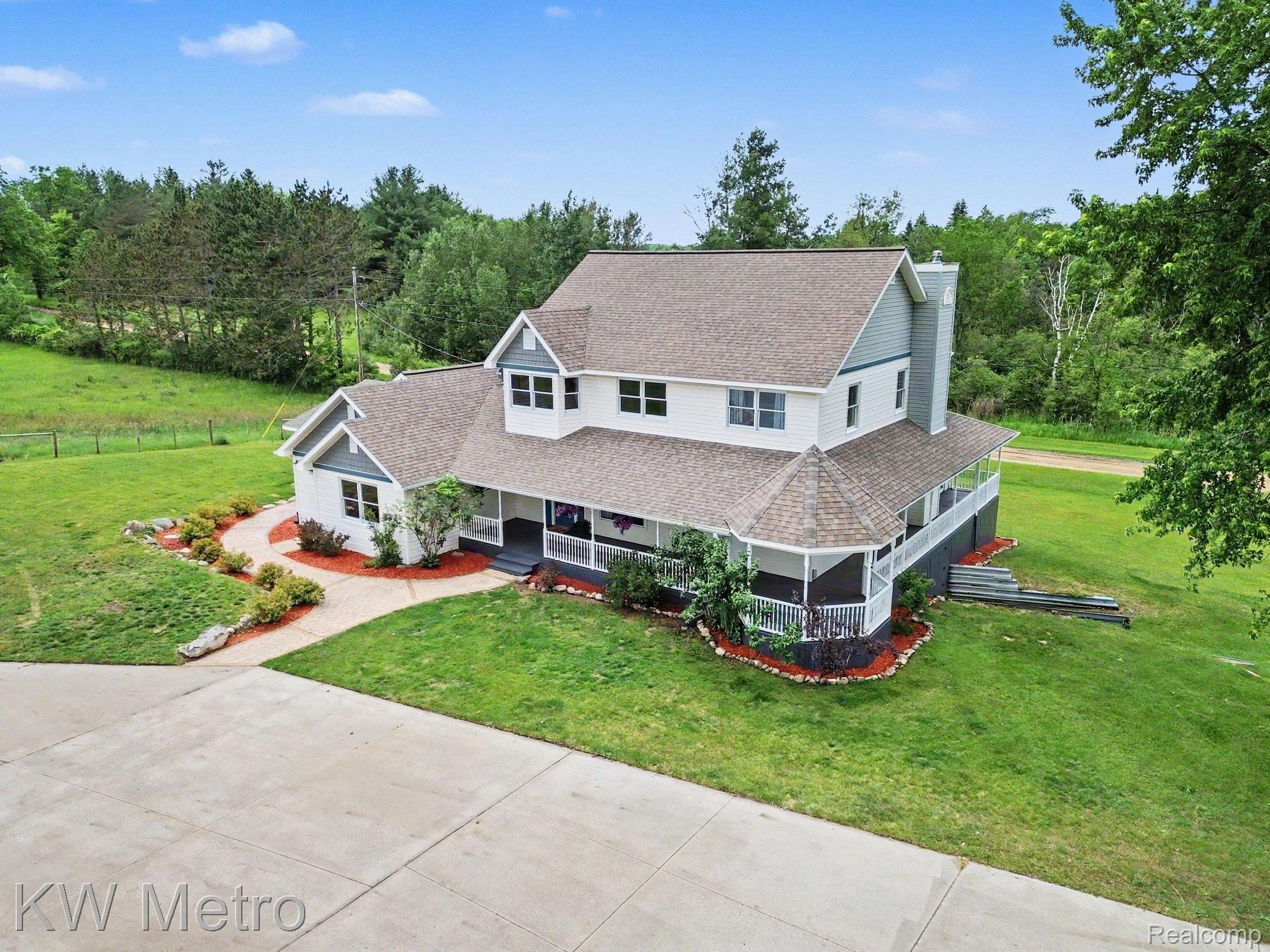 2682 East Haskell Lake Road Harrison, MI 48625 - Photo 2 of 61 Grand two-story residence featuring a perimeter porch, multiple dormer windows, and a prominent octagonal turret